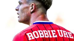 Why does Robbie Ure have Robbie Ure on his Scotland shirt?